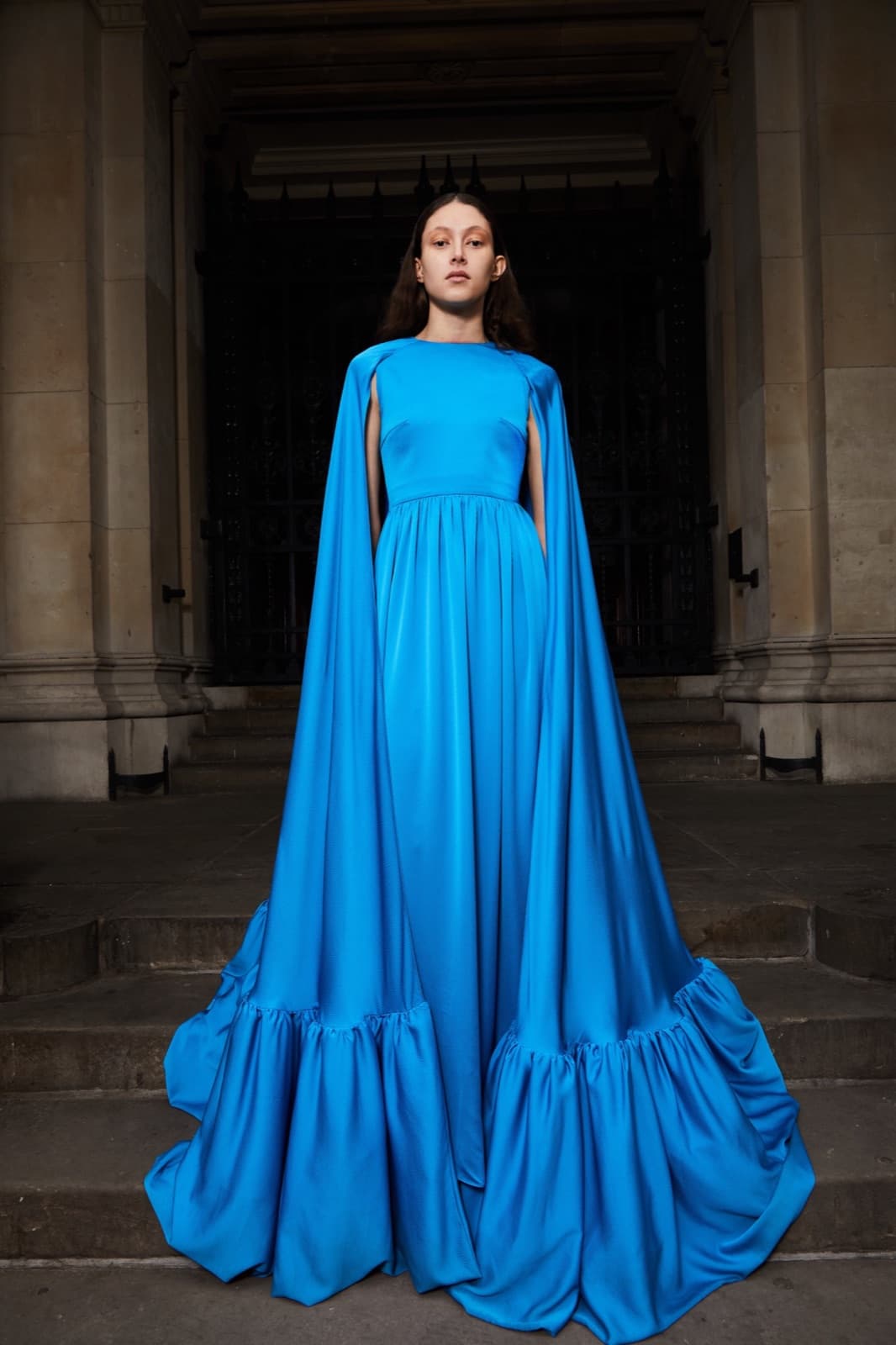 Long tousled waves beside a cerulean cape gown.